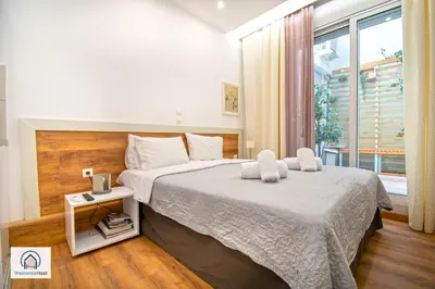 a bedroom with a large bed and a window at Syntagma Square Athenian apartments in Athens