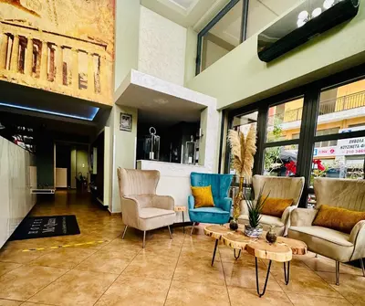 a living room with chairs and a coffee table at Mc Queen Rooms & Apartments in Athens