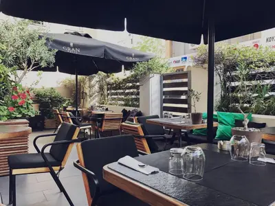 a restaurant with tables and chairs and an umbrella at Mc Queen Rooms & Apartments in Athens