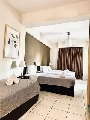 a hotel room with two beds and a window at Mc Queen Rooms & Apartments in Athens