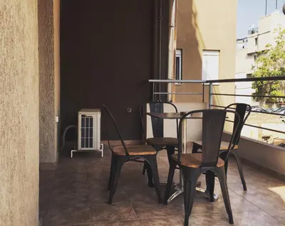 two chairs and a table on a balcony at Mc Queen Rooms & Apartments in Athens