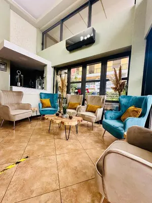 a living room with blue chairs and a table at Mc Queen Rooms & Apartments in Athens