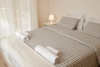 a bedroom with two beds with towels on them at Cozy Bright Apartment in Athens