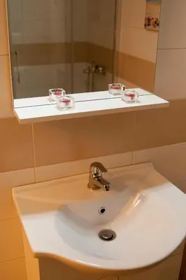 a bathroom sink with a mirror and a sink at Cozy Bright Apartment in Athens