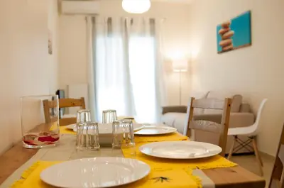 a table with plates and glasses on top of it at Cozy Bright Apartment in Athens