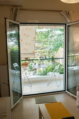 a room with a sliding glass door leading to a balcony at Cozy Bright Apartment in Athens