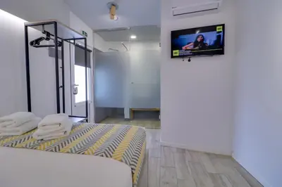 a room with a bed and a tv on a wall at athensotel in Athens