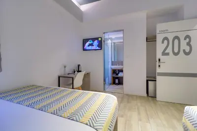 a bedroom with a bed and a desk and a tv at athensotel in Athens