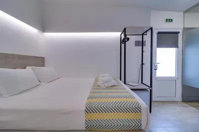 a bedroom with a large white bed and a glass door at athensotel in Athens