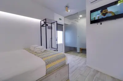 a bedroom with a bed and a flat screen tv at athensotel in Athens