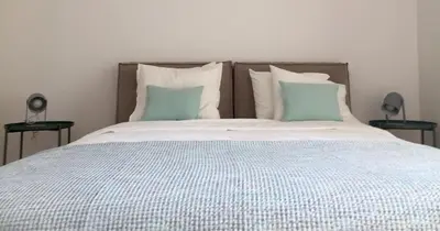 a bed with blue and white sheets and pillows at Truman Apartment - Athens in Athens