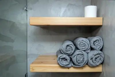 a pile of towels on a wooden shelf in a bathroom at Truman Apartment - Athens in Athens