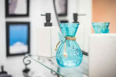 a blue glass vase sitting on a glass table at Athenz Downtown Studio in Athens