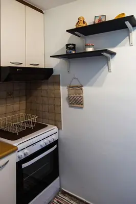 a kitchen with a stove and shelves on the wall at Romeo & Juliet -Modern & Stylish Apartment With City View in Egaleo-Athens in Athens
