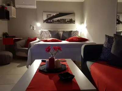 a hotel room with a bed and a table with flowers on it at Romeo & Juliet -Modern & Stylish Apartment With City View in Egaleo-Athens in Athens