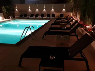 a pool with a row of chairs next to it at Athens coast hotel in Athens