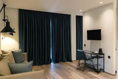 a living room with a couch and a table with a television at Athens coast hotel in Athens