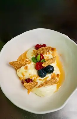 a white plate with a dessert with fruit and nuts at Athens coast hotel in Athens