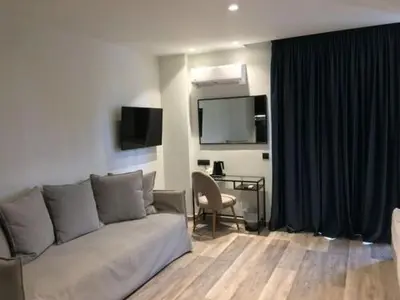 a living room with a couch and a table and a television at Athens coast hotel in Athens