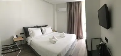 a hotel room with a white bed with towels on it at Athens coast hotel in Athens
