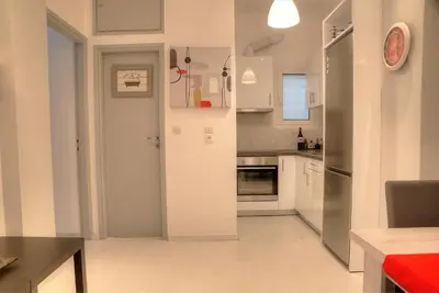 a kitchen with white cabinets and a door leading into it at Cosy apartment in Glyfada center in Athens