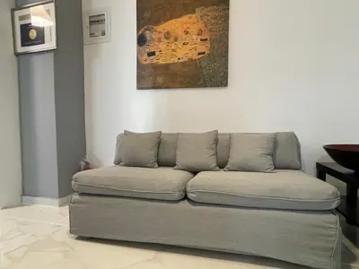 a couch in a living room with a painting on the wall at Cosy apartment in Glyfada center in Athens