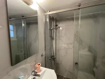 a bathroom with a shower and a sink and a mirror at Cosy apartment in Glyfada center in Athens