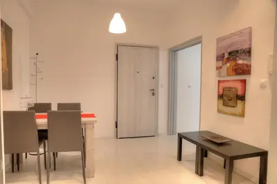 a dining room with a table and chairs and a door at Cosy apartment in Glyfada center in Athens