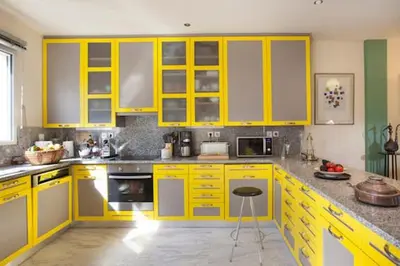 a yellow kitchen with yellow cabinets and a counter at Maison de Famille in Athens