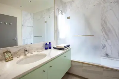 a white bathroom with a sink and a mirror at Maison de Famille in Athens