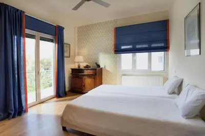 a bedroom with a large bed and a window at Maison de Famille in Athens
