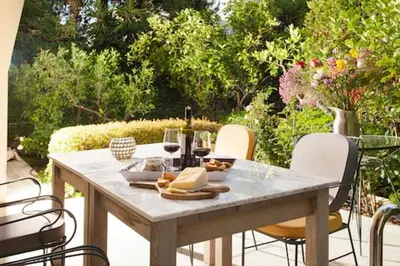 a table with glasses of wine and food on a patio at Maison de Famille in Athens