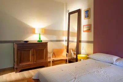 a bedroom with a bed and a dresser and a mirror at Maison de Famille in Athens