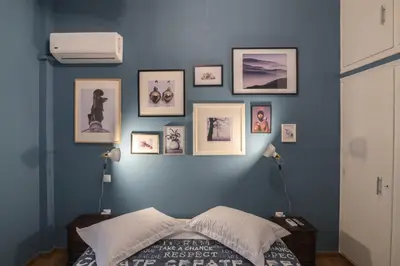 a bedroom with a blue wall with pictures on it at On the way to Ithaca in Athens