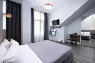 a hotel room with a white bed and a desk at Enattica Monastiraki Living in Athens