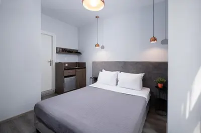 a bedroom with a large bed with white sheets at Enattica Monastiraki Living in Athens