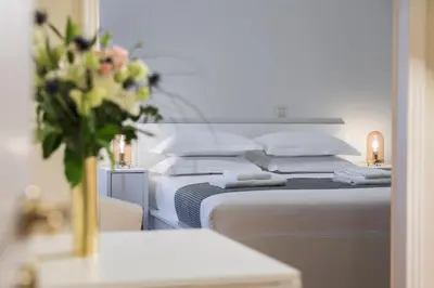 a bedroom with two beds and a vase of flowers at The Parliament Studio in Athens