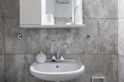 a bathroom with a white sink and a mirror at The Parliament Studio in Athens