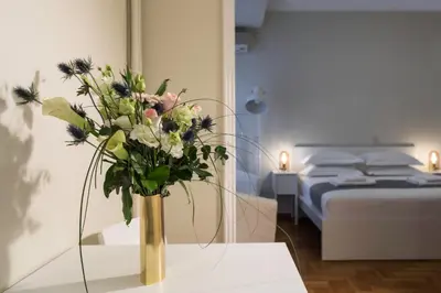 a vase of flowers on a table in a bedroom at The Parliament Studio in Athens