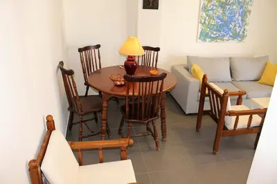a living room with a table and chairs and a couch at Apartment SEA VIEW in front of the beach of Agia Marina in Porto Rafti