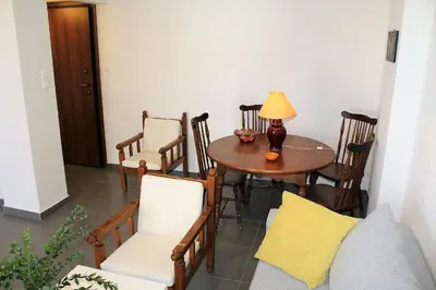 a room with a table and chairs and a lamp at Apartment SEA VIEW in front of the beach of Agia Marina in Porto Rafti