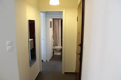 a hallway of a bathroom with a toilet and a sink at Apartment SEA VIEW in front of the beach of Agia Marina in Porto Rafti
