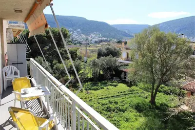 a balcony of a house with a view of a garden at Apartment SEA VIEW in front of the beach of Agia Marina in Porto Rafti