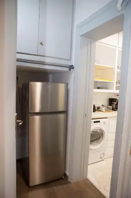 a kitchen with a stainless steel refrigerator and a washing machine at Athens Center Spacious Luxury Apartment in Athens