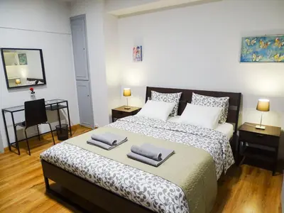 a bedroom with a large bed with two towels on it at Athens Center Spacious Luxury Apartment in Athens