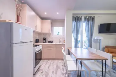 a kitchen with a table and a white refrigerator at Sunny studio with Starlight balcony in Athens