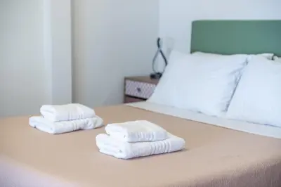 two stacks of towels sitting on a bed at Sunny studio with Starlight balcony in Athens