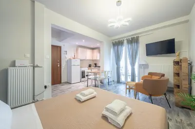 a kitchen and living room with a table and chairs at Sunny studio with Starlight balcony in Athens