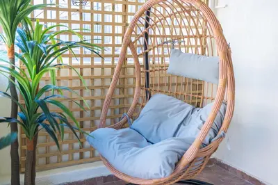 a wicker chair with a pillow in a room with a plant at Sunny studio with Starlight balcony in Athens