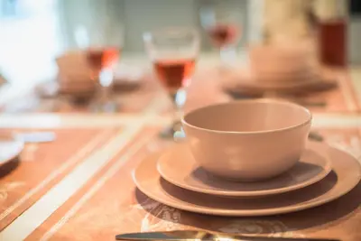 a cup and saucer on a wooden table with wine glasses at 